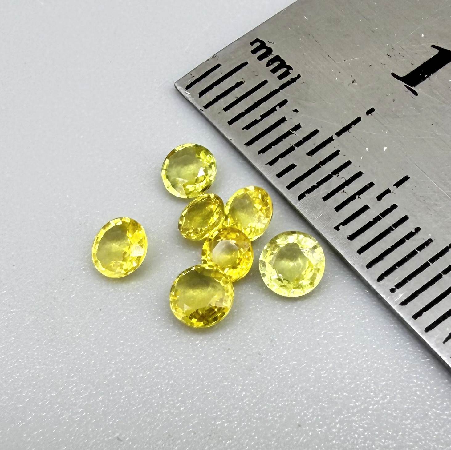 Yellow sapphire parcel in oval and round cuts from Bangkaja, Thailand showing lemon to light golden tones with bright natural brilliance.