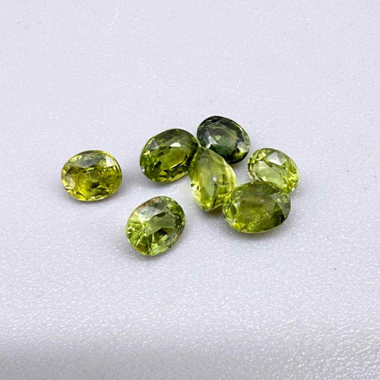 Green sapphire parcel in oval cuts from Bangkaja, Thailand showing yellowish-green to olive tones with natural brilliance.