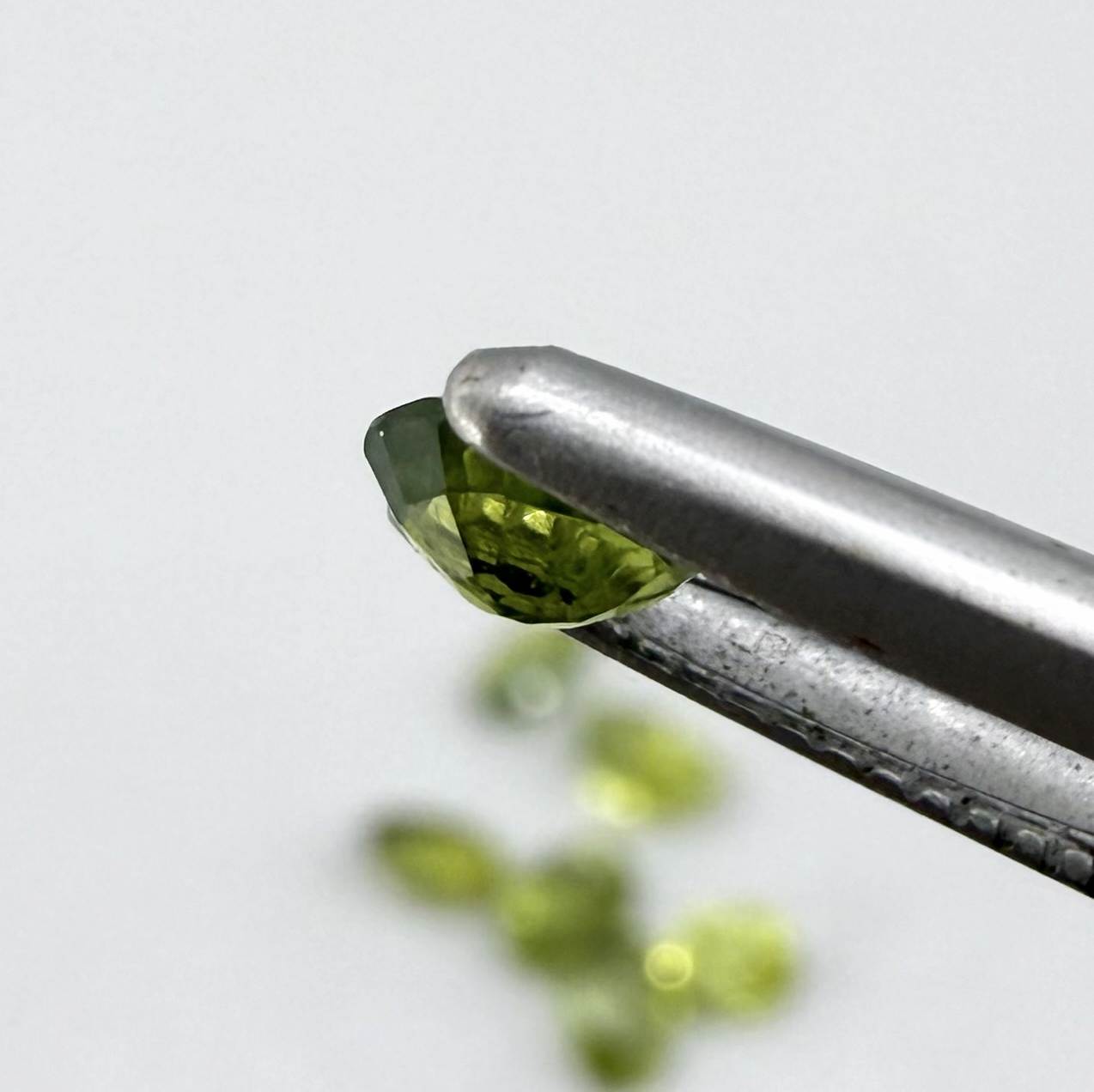 Green sapphire parcel in oval cuts from Bangkaja, Thailand showing yellowish-green to olive tones with natural brilliance.