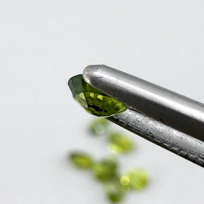 Green sapphire parcel in oval cuts from Bangkaja, Thailand showing yellowish-green to olive tones with natural brilliance.