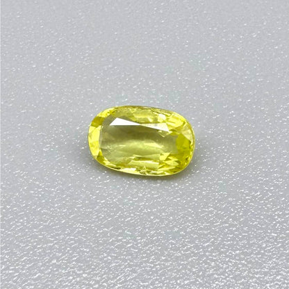 Cushion-cut lemon yellow sapphire from Bangkaja, Thailand with soft bright color and natural brilliance.