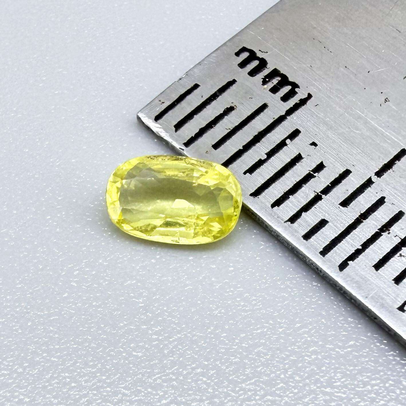 Cushion-cut lemon yellow sapphire from Bangkaja, Thailand with soft bright color and natural brilliance.