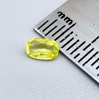 Cushion-cut lemon yellow sapphire from Bangkaja, Thailand with soft bright color and natural brilliance.