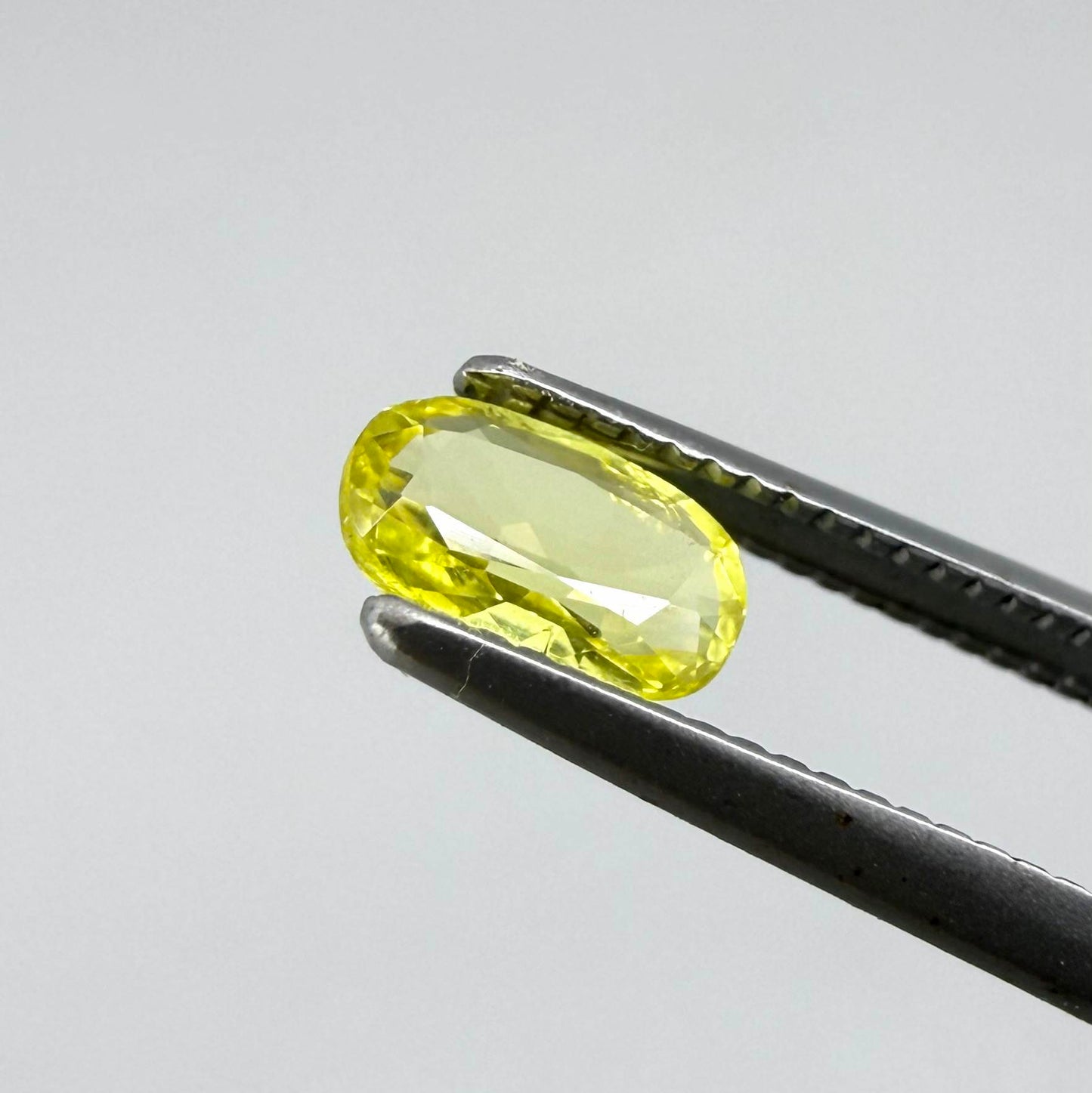 Cushion-cut lemon yellow sapphire from Bangkaja, Thailand with soft bright color and natural brilliance.