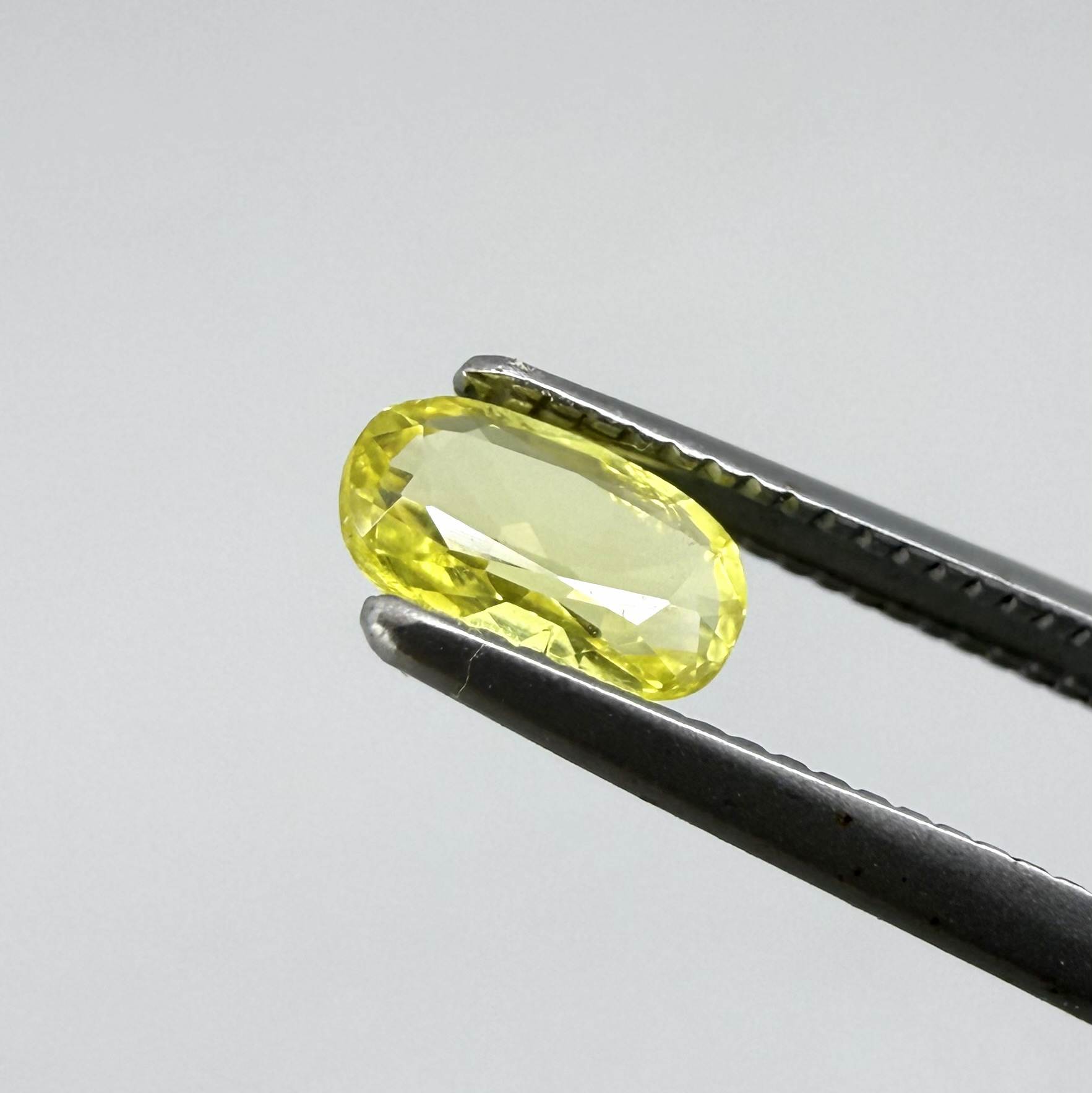 Cushion-cut lemon yellow sapphire from Bangkaja, Thailand with soft bright color and natural brilliance.