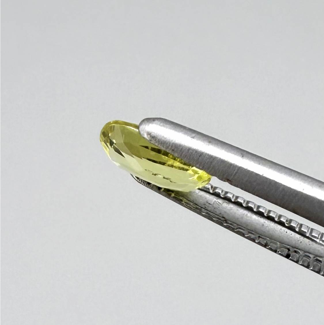 Cushion-cut lemon yellow sapphire from Bangkaja, Thailand with soft bright color and natural brilliance.