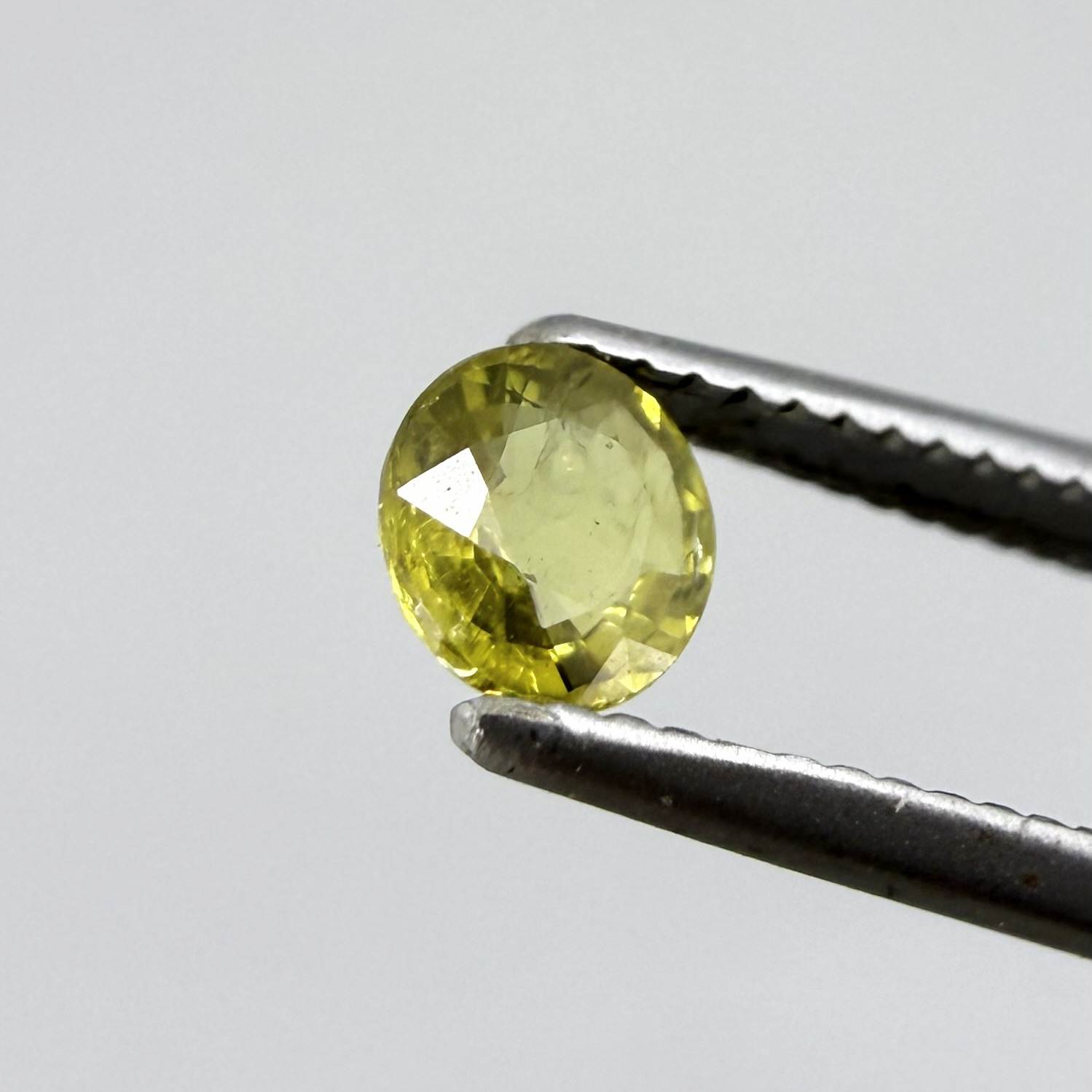 Round light lemon yellow sapphire from Bangkaja, Thailand with soft bright color and natural brilliance.