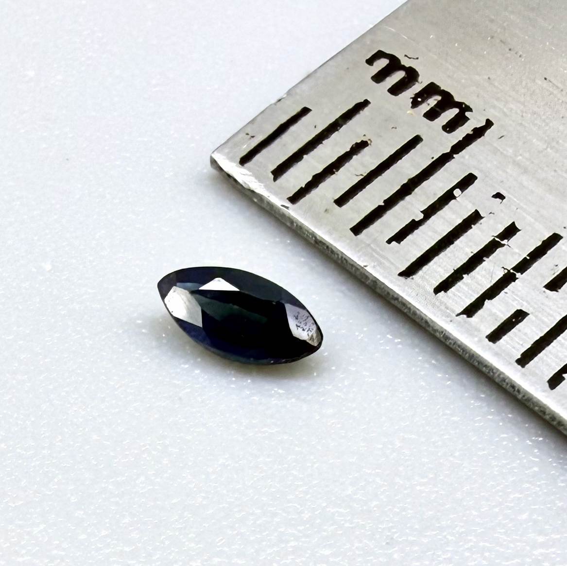 Marquise dark teal blue sapphire from Bangkaja, Thailand with deep blue-green tone and natural color zoning.