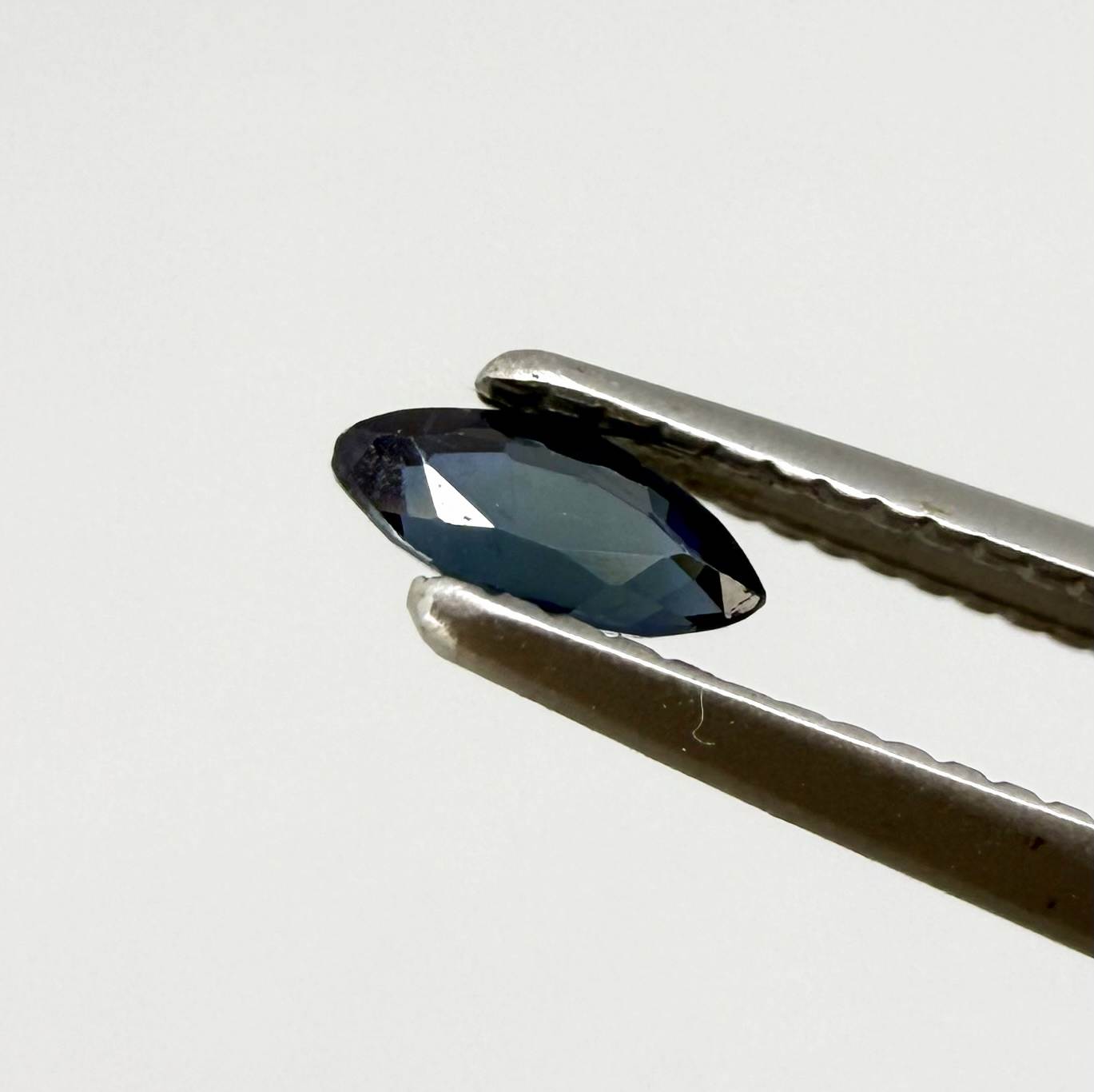 Marquise dark teal blue sapphire from Bangkaja, Thailand with deep blue-green tone and natural color zoning.