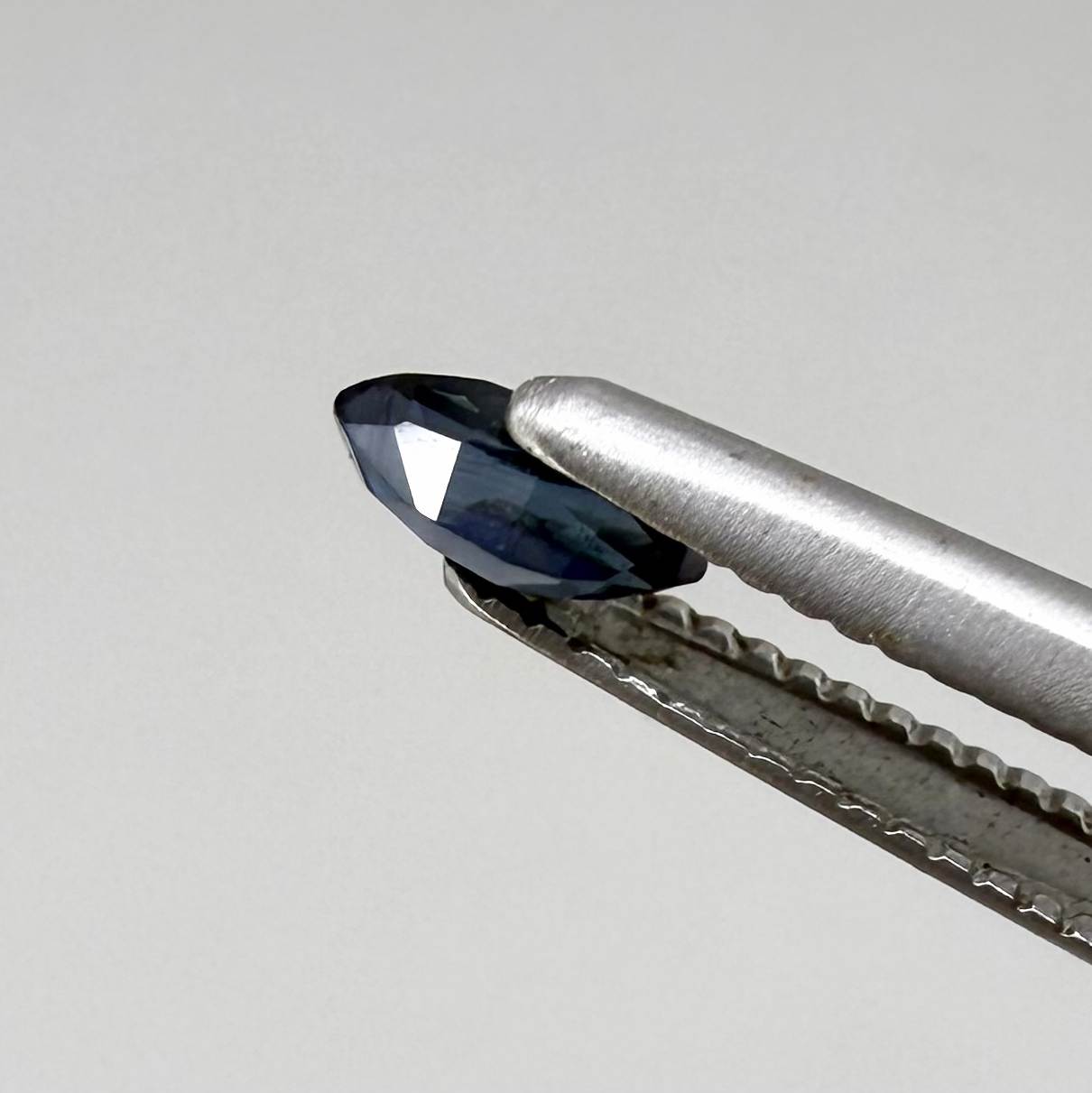 Marquise dark teal blue sapphire from Bangkaja, Thailand with deep blue-green tone and natural color zoning.