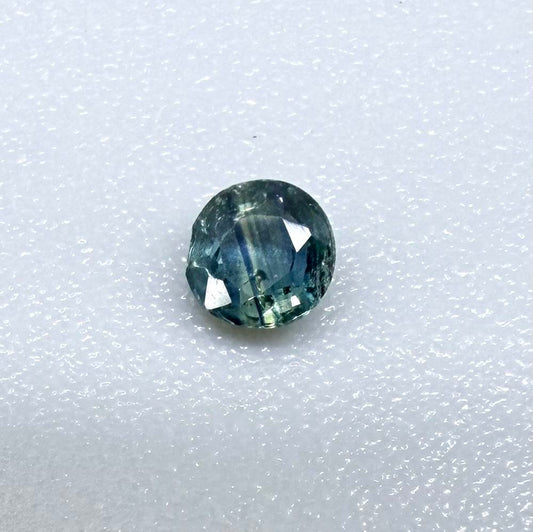 Round petrol blue sapphire from Bangkaja, Thailand with deep blue-green tone and natural color zoning.