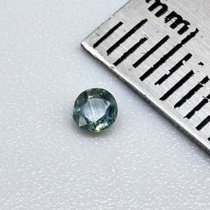 Round petrol blue sapphire from Bangkaja, Thailand with deep blue-green tone and natural color zoning.