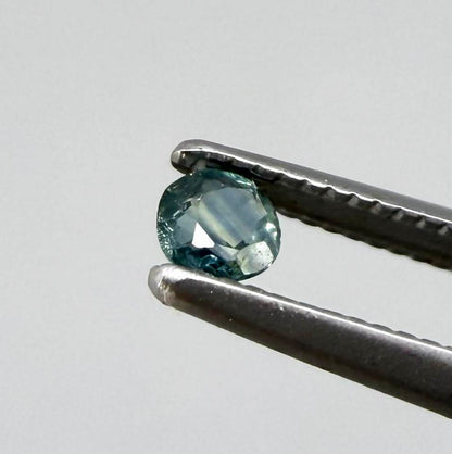 Round petrol blue sapphire from Bangkaja, Thailand with deep blue-green tone and natural color zoning.