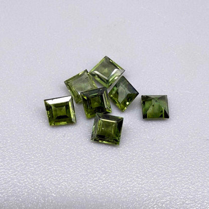 Green sapphire parcel in square cuts from Bangkaja, Thailand showing olive to yellowish-green tones with natural brilliance.