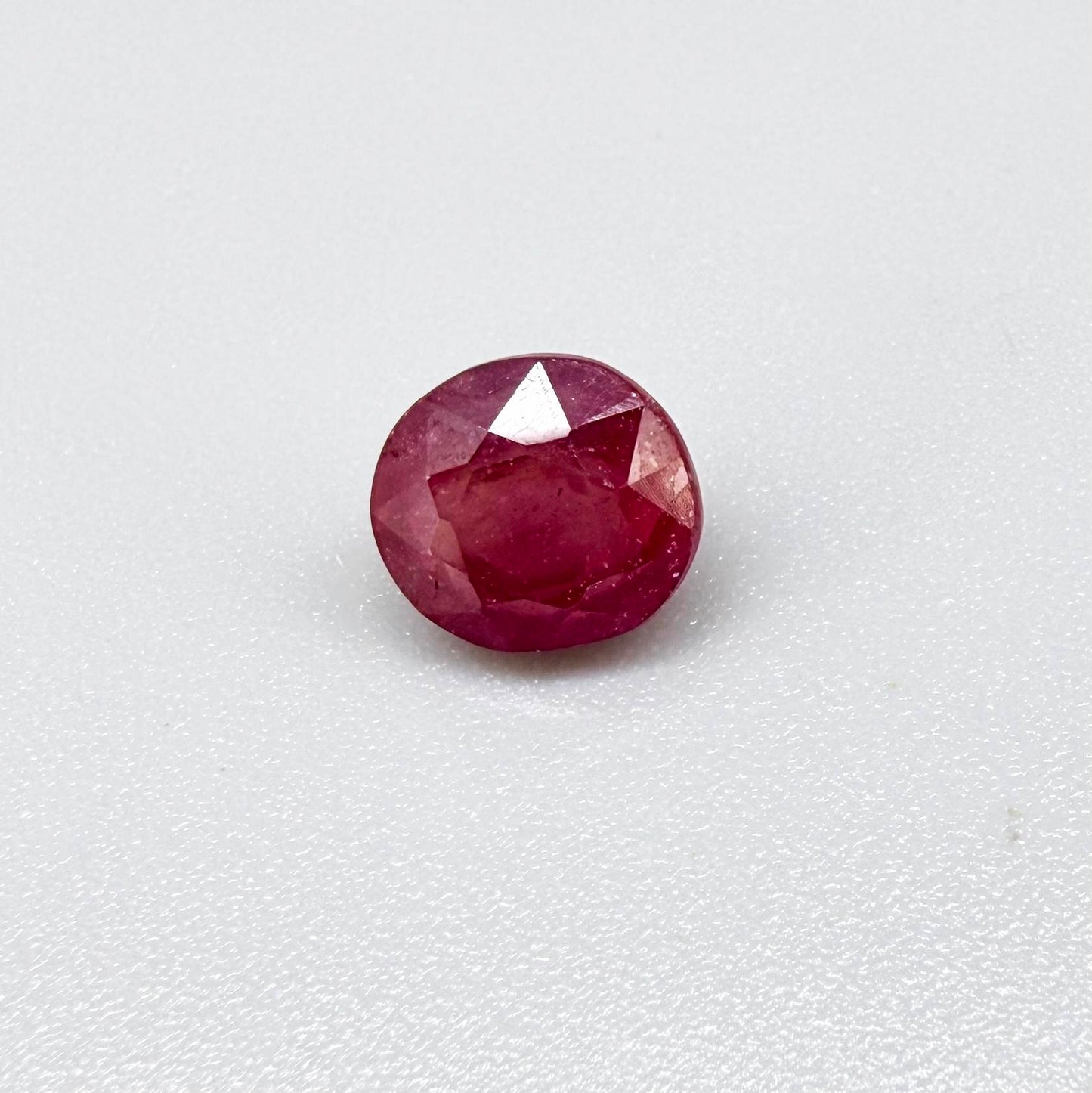 Oval reddish pink ruby from Mozambique with soft rosé tone, visible natural inclusions and gentle semi-transparent appearance.