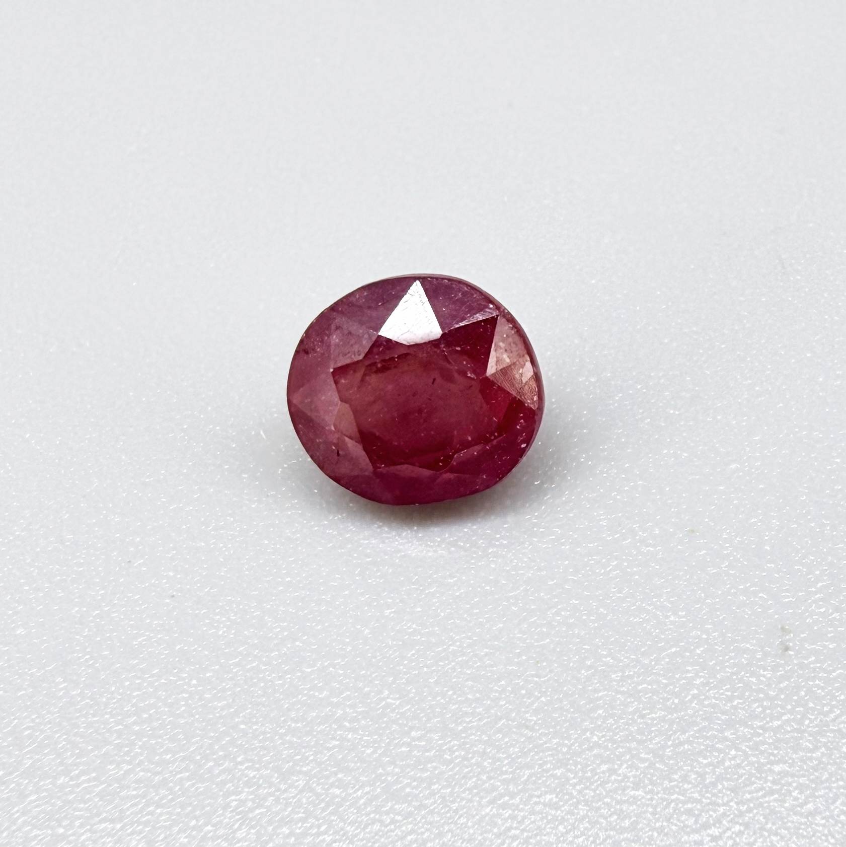 Oval reddish pink ruby from Mozambique with soft rosé tone, visible natural inclusions and gentle semi-transparent appearance.