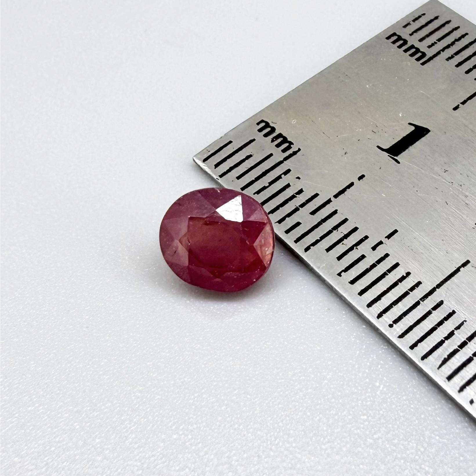 Oval reddish pink ruby from Mozambique with soft rosé tone, visible natural inclusions and gentle semi-transparent appearance.
