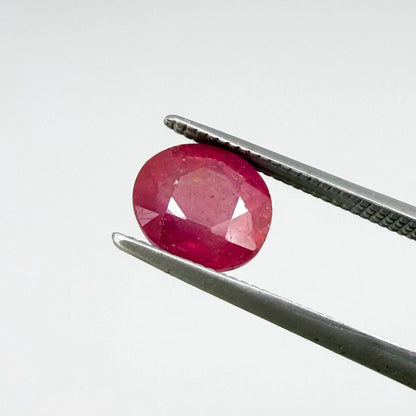 Oval reddish pink ruby from Mozambique with soft rosé tone, visible natural inclusions and gentle semi-transparent appearance.