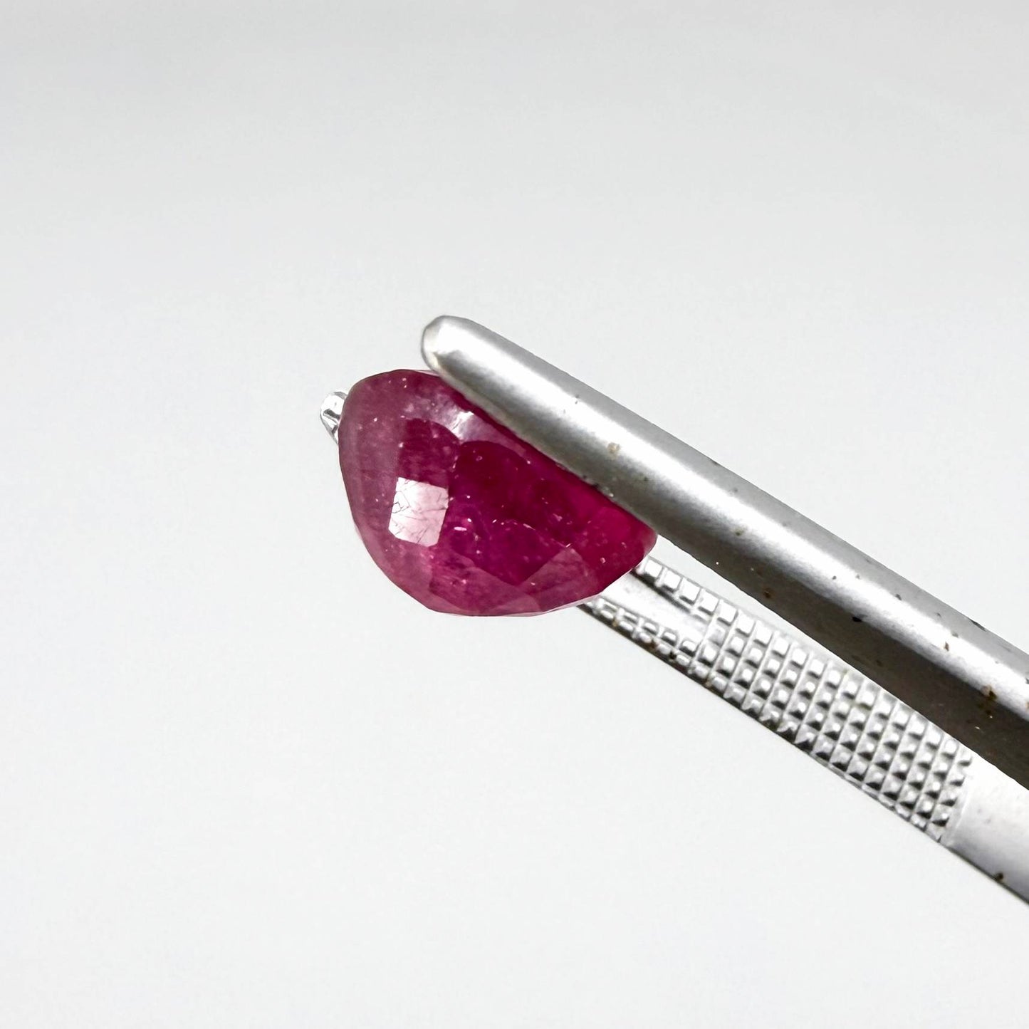 Oval reddish pink ruby from Mozambique with soft rosé tone, visible natural inclusions and gentle semi-transparent appearance.