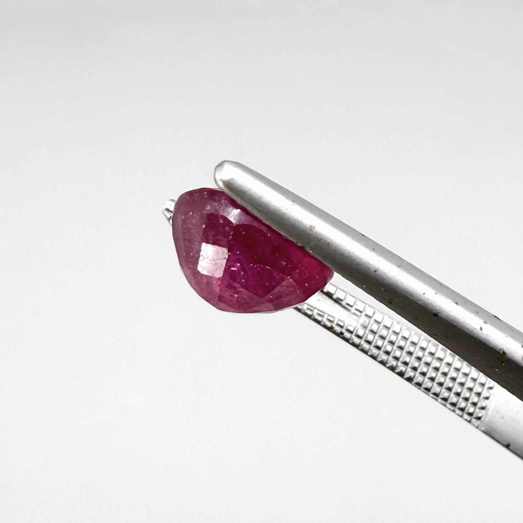 Oval reddish pink ruby from Mozambique with soft rosé tone, visible natural inclusions and gentle semi-transparent appearance.