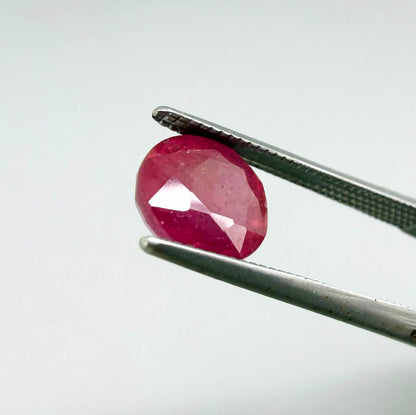 Oval reddish pink ruby from Mozambique with soft rosé tone, visible natural inclusions and gentle semi-transparent appearance.