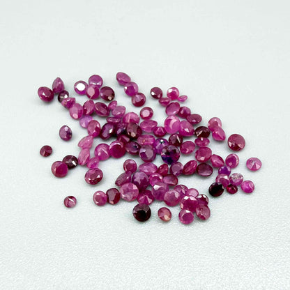 Ruby parcel with mixed pinkish red to reddish pink tones in small faceted cuts, showing natural inclusions and lively brilliance.