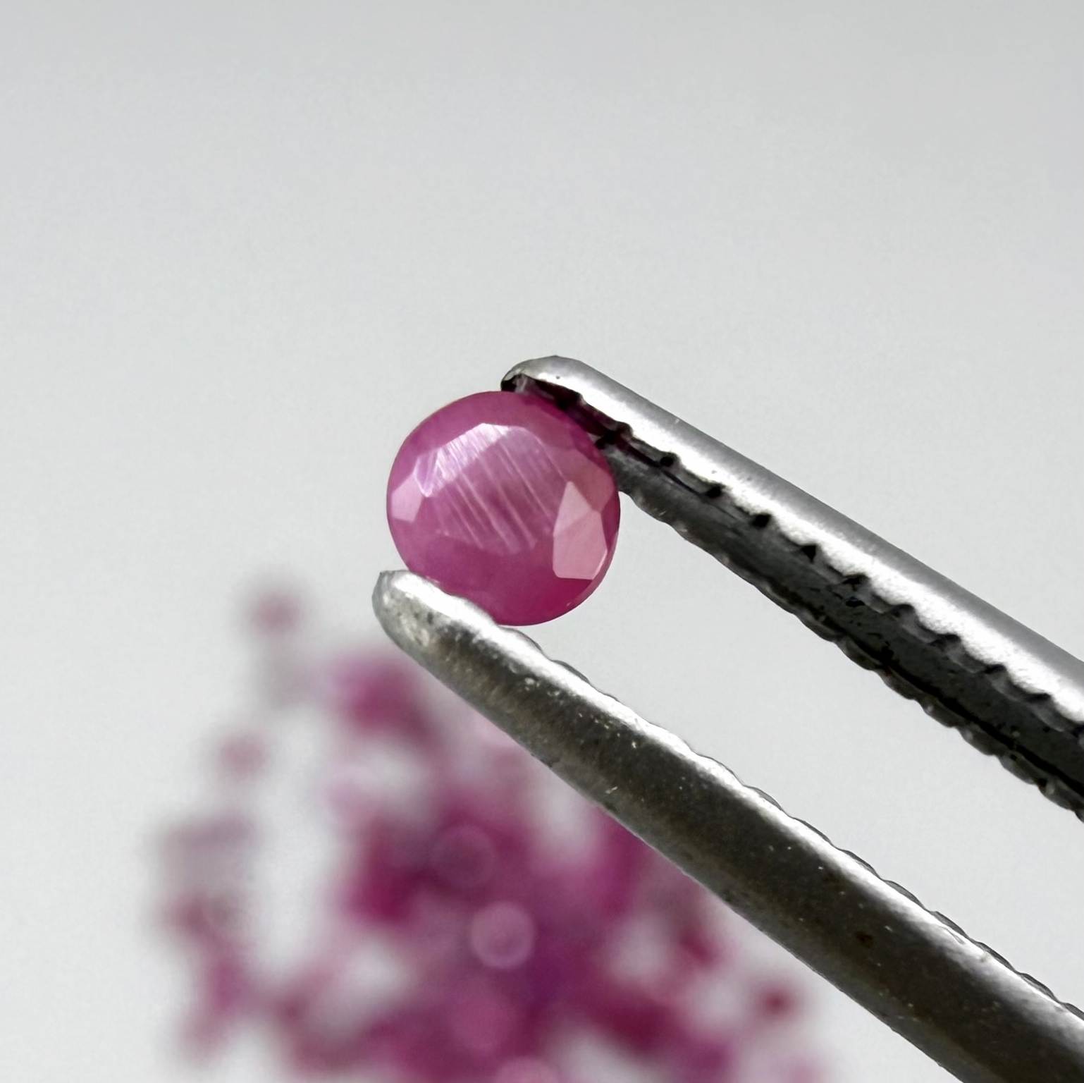 Ruby parcel with mixed pinkish red to reddish pink tones in small faceted cuts, showing natural inclusions and lively brilliance.