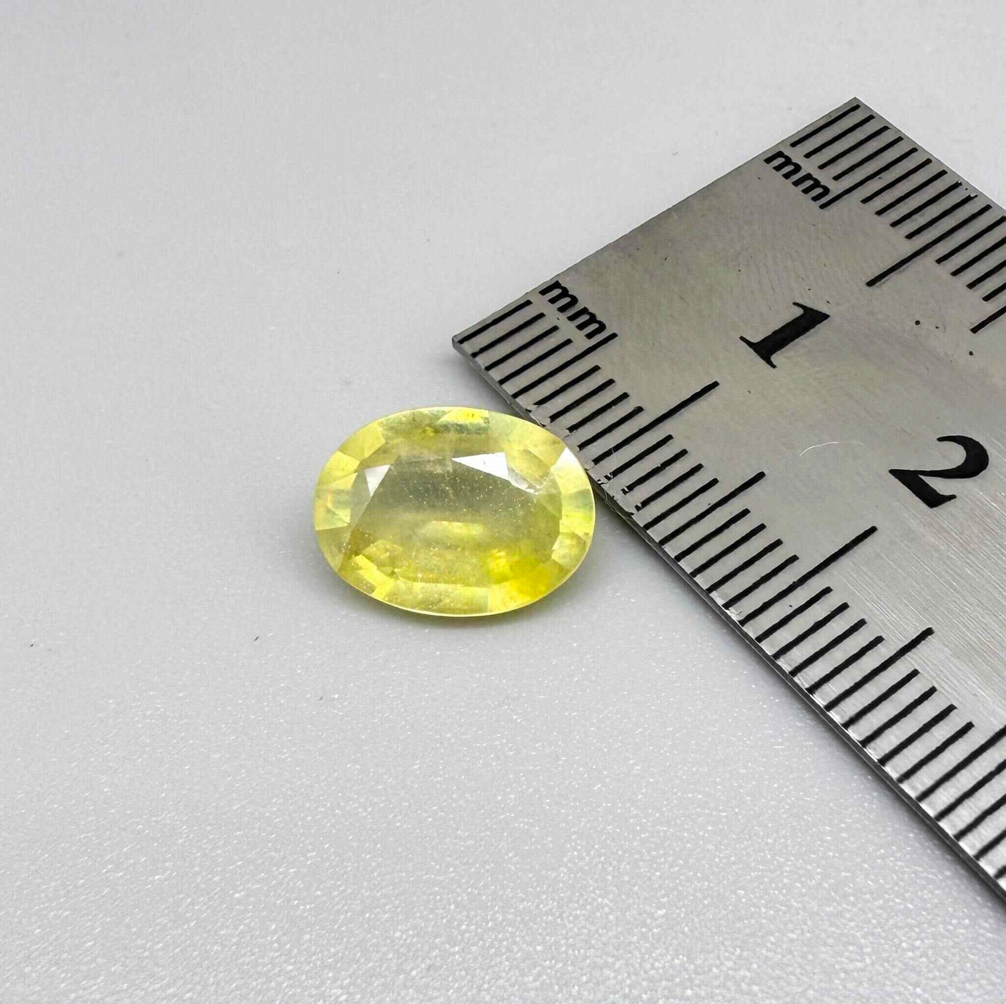 Oval yellow sapphire from Africa, 4ct, with bright lemon-yellow color, slight natural inclusions and a transparent to lightly silky appearance.