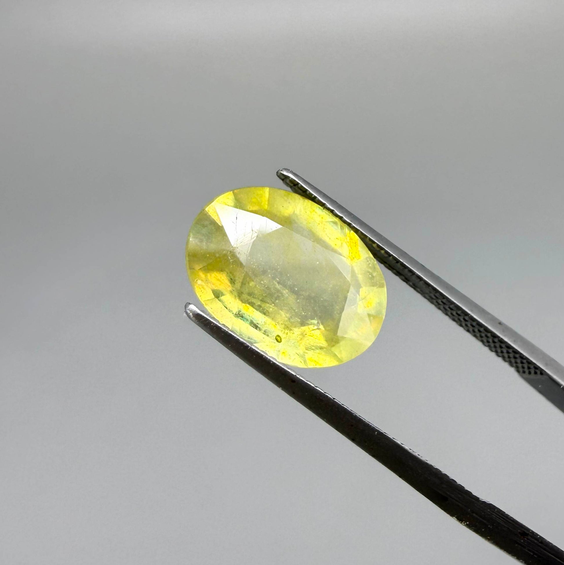 Oval yellow sapphire from Africa, 4ct, with bright lemon-yellow color, slight natural inclusions and a transparent to lightly silky appearance.