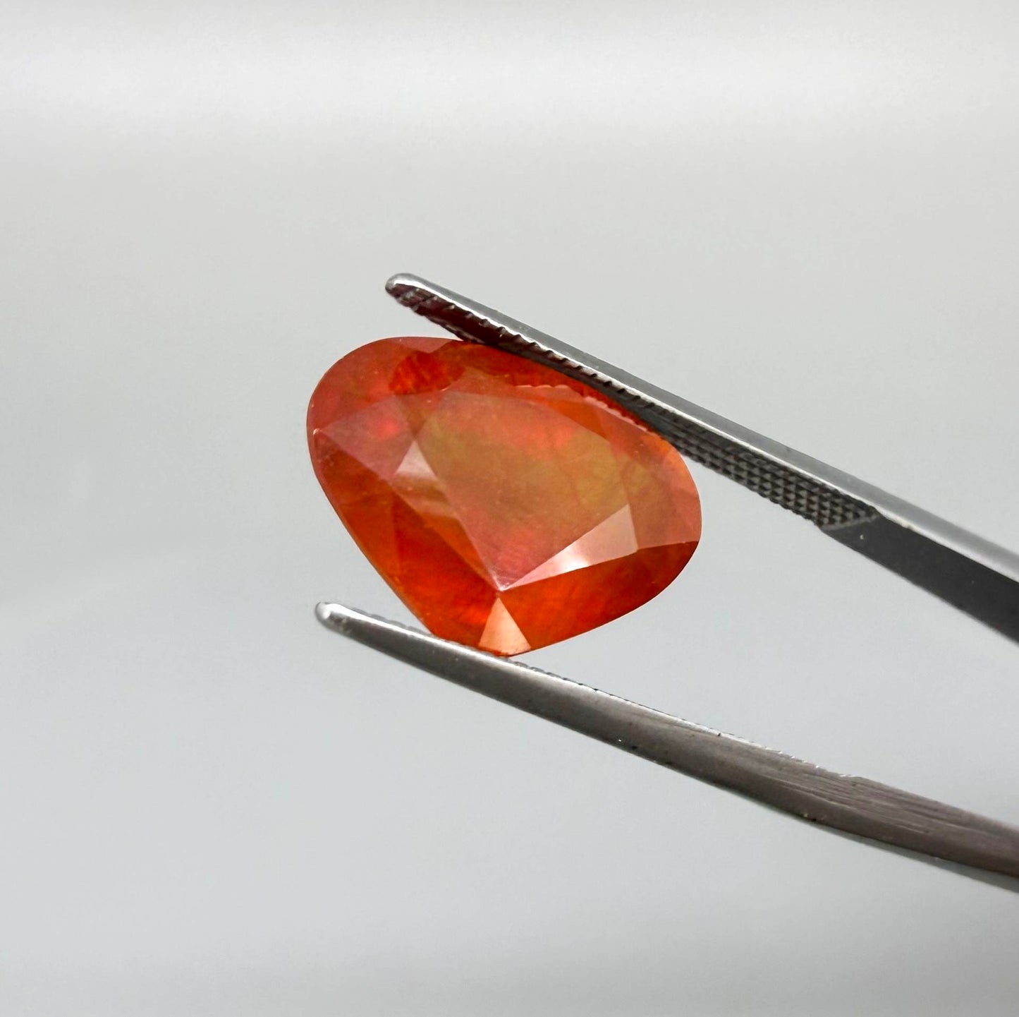 Heart cut orange sapphire from Africa, 6.76ct, with vivid orange to reddish-orange color, visible natural inclusions and a transparent to slightly silky appearance.