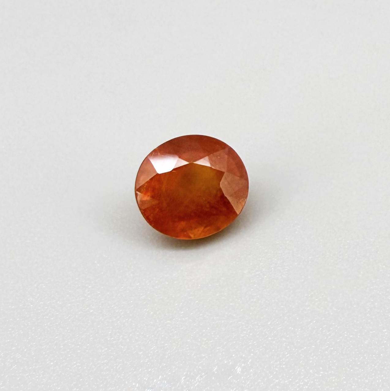 Oval orange sapphire from Africa, 4ct, with vivid orange to mandarin color, visible natural inclusions and a transparent to slightly silky appearance.