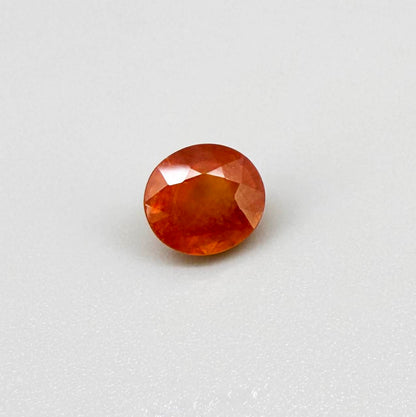 Oval orange sapphire from Africa, 4ct, with vivid orange to mandarin color, visible natural inclusions and a transparent to slightly silky appearance.