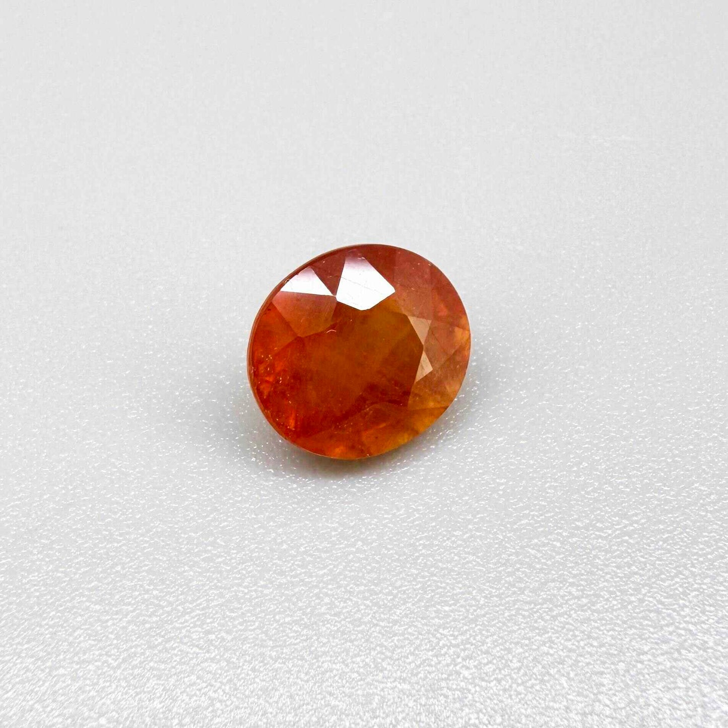 Oval orange sapphire from Africa, 4ct, with vivid orange to mandarin color, visible natural inclusions and a transparent to slightly silky appearance.