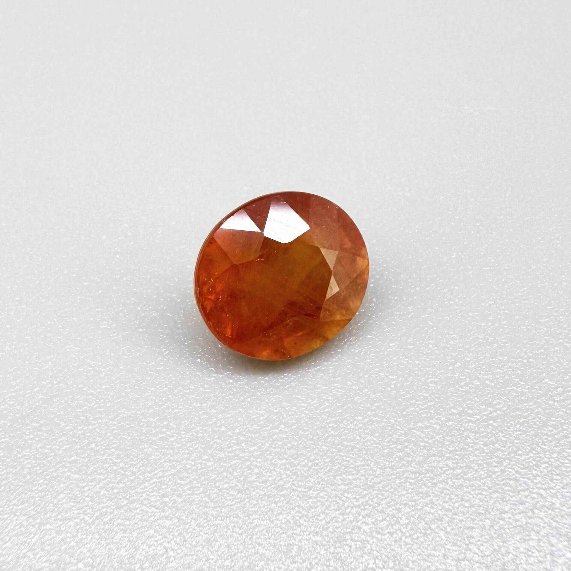 Oval orange sapphire from Africa, 4ct, with vivid orange to mandarin color, visible natural inclusions and a transparent to slightly silky appearance.