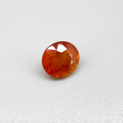 Oval orange sapphire from Africa, 4ct, with vivid orange to mandarin color, visible natural inclusions and a transparent to slightly silky appearance.