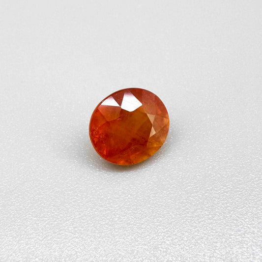 Oval orange sapphire from Africa, 4ct, with vivid orange to mandarin color, visible natural inclusions and a transparent to slightly silky appearance.