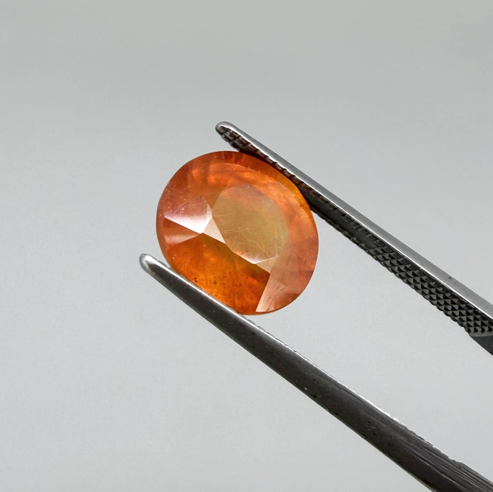 Oval orange sapphire from Africa, 4ct, with vivid orange to mandarin color, visible natural inclusions and a transparent to slightly silky appearance.
