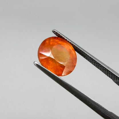 Oval orange sapphire from Africa, 4ct, with vivid orange to mandarin color, visible natural inclusions and a transparent to slightly silky appearance.