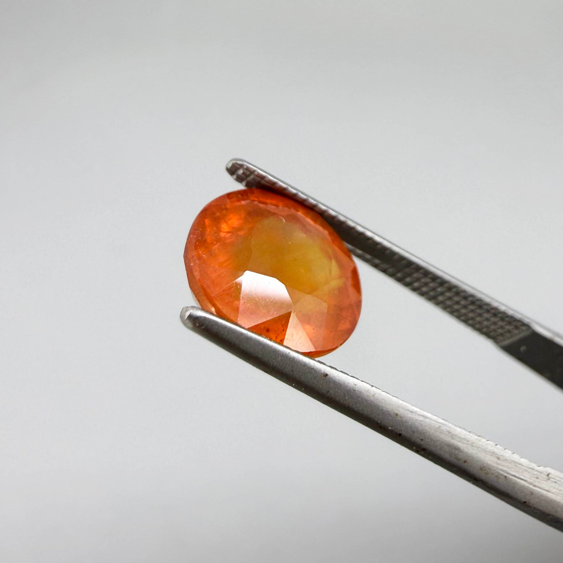 Oval orange sapphire from Africa, 4ct, with vivid orange to mandarin color, visible natural inclusions and a transparent to slightly silky appearance.