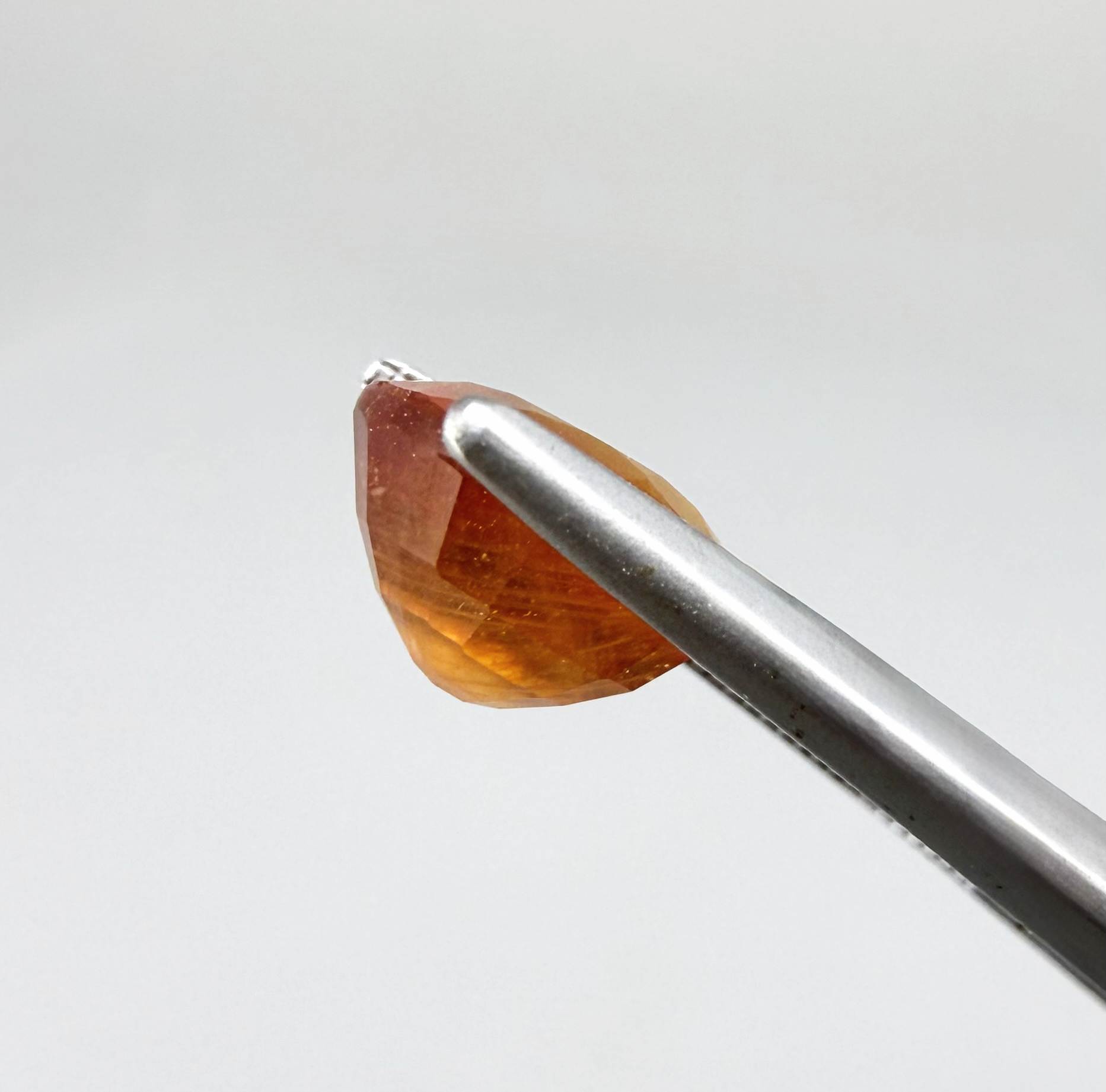 Oval orange sapphire from Africa, 4ct, with vivid orange to mandarin color, visible natural inclusions and a transparent to slightly silky appearance.