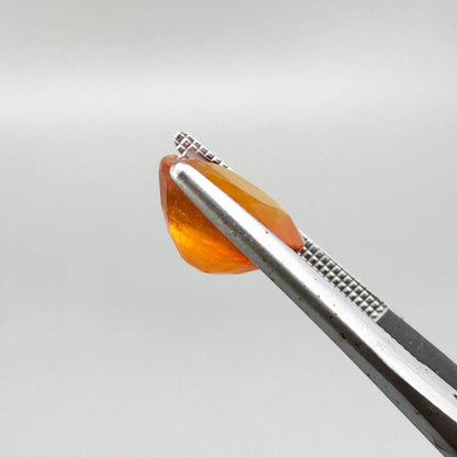 Oval orange sapphire from Africa, 6.2ct, with vivid orange color and a lighter yellowish center, visible natural inclusions and a transparent to slightly silky appearance.
