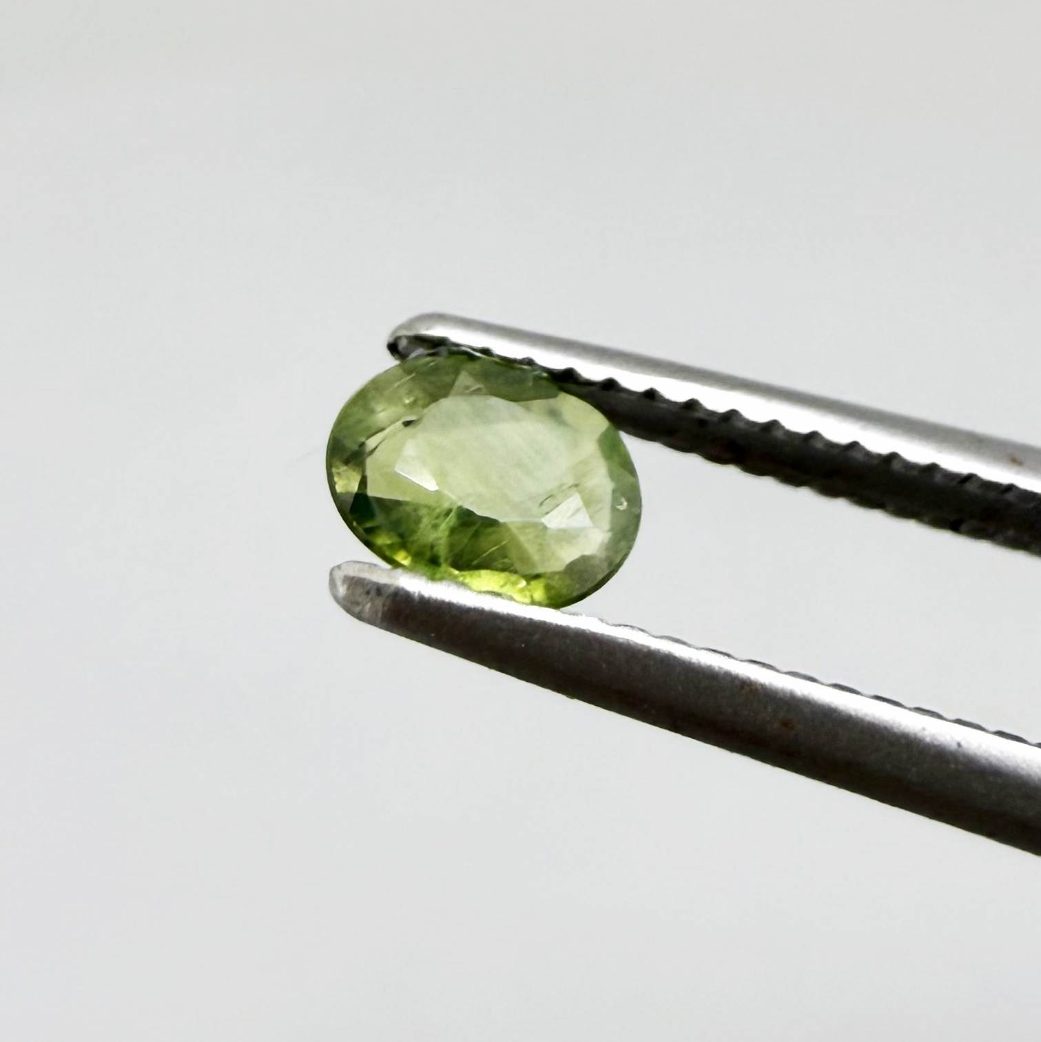 Oval green sapphire from Thailand, 0.29ct, unheated, with fresh olive-green color, eye-clean clarity and a transparent appearance.