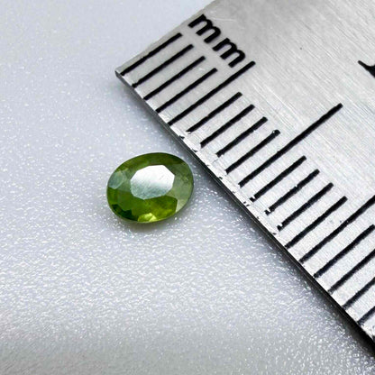Oval green sapphire from Thailand, 0.35ct, unheated, with rich olive-green color, visible natural inclusions and a transparent to slightly silky appearance.