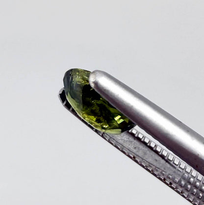 Oval green sapphire from Thailand, 0.5ct, unheated, with deep olive to forest green color, visible natural inclusions and a transparent to slightly silky appearance.