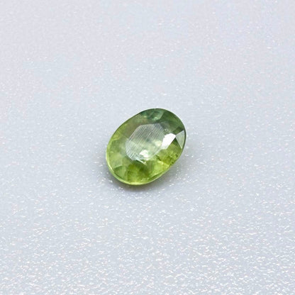 Oval light green sapphire from Thailand, 0.33ct, unheated, with soft green color, visible banding and natural inclusions and a transparent to slightly silky appearance.
