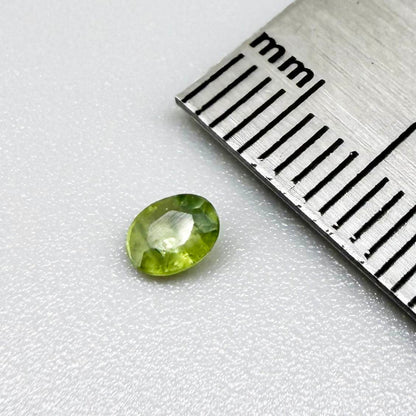 Oval light green sapphire from Thailand, 0.33ct, unheated, with soft green color, visible banding and natural inclusions and a transparent to slightly silky appearance.