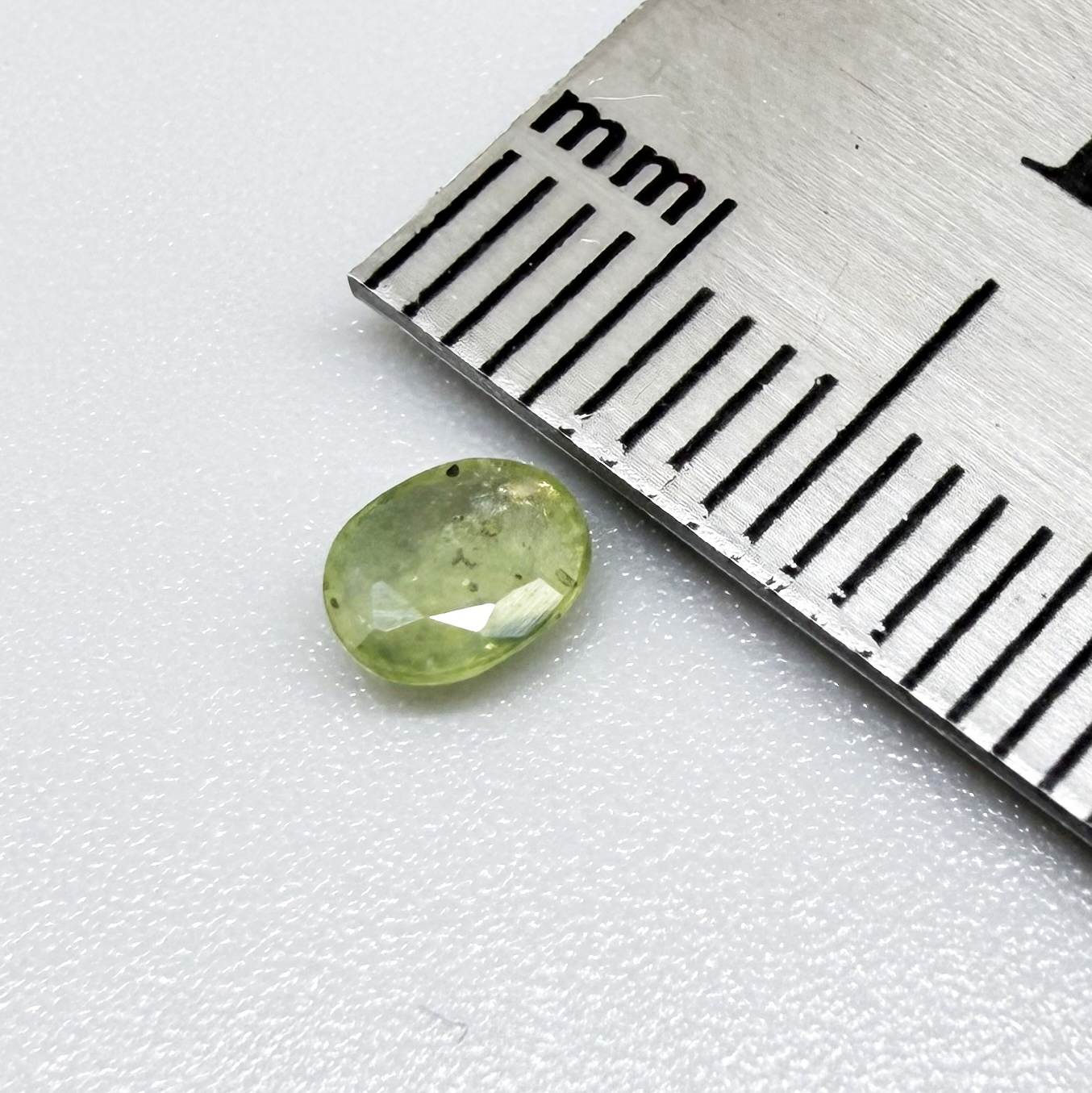 Oval light green sapphire from Thailand, 0.42ct, unheated, with soft pistachio-green color, visible natural inclusions and a transparent to slightly silky appearance.