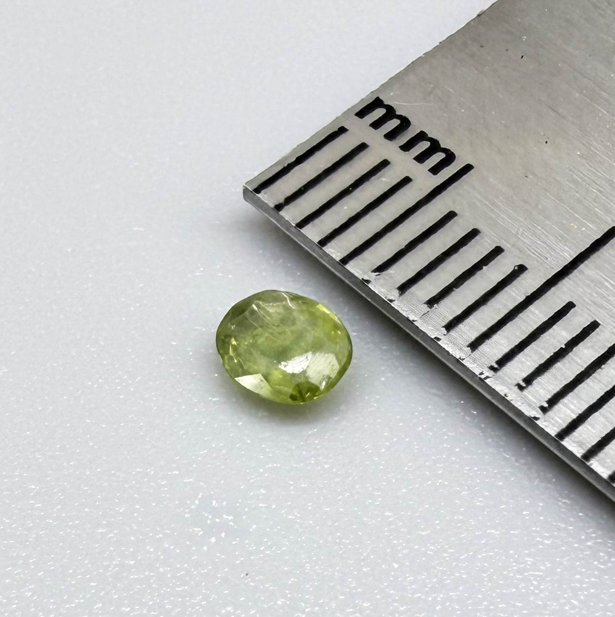 Oval light green sapphire from Thailand, 0.31ct, unheated, with fresh yellow-green color, visible natural inclusions and a transparent to slightly silky appearance.