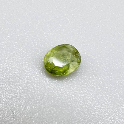 Oval light green sapphire from Thailand, 0.31ct, unheated, with fresh yellow-green color, visible natural inclusions and a transparent to slightly silky appearance.