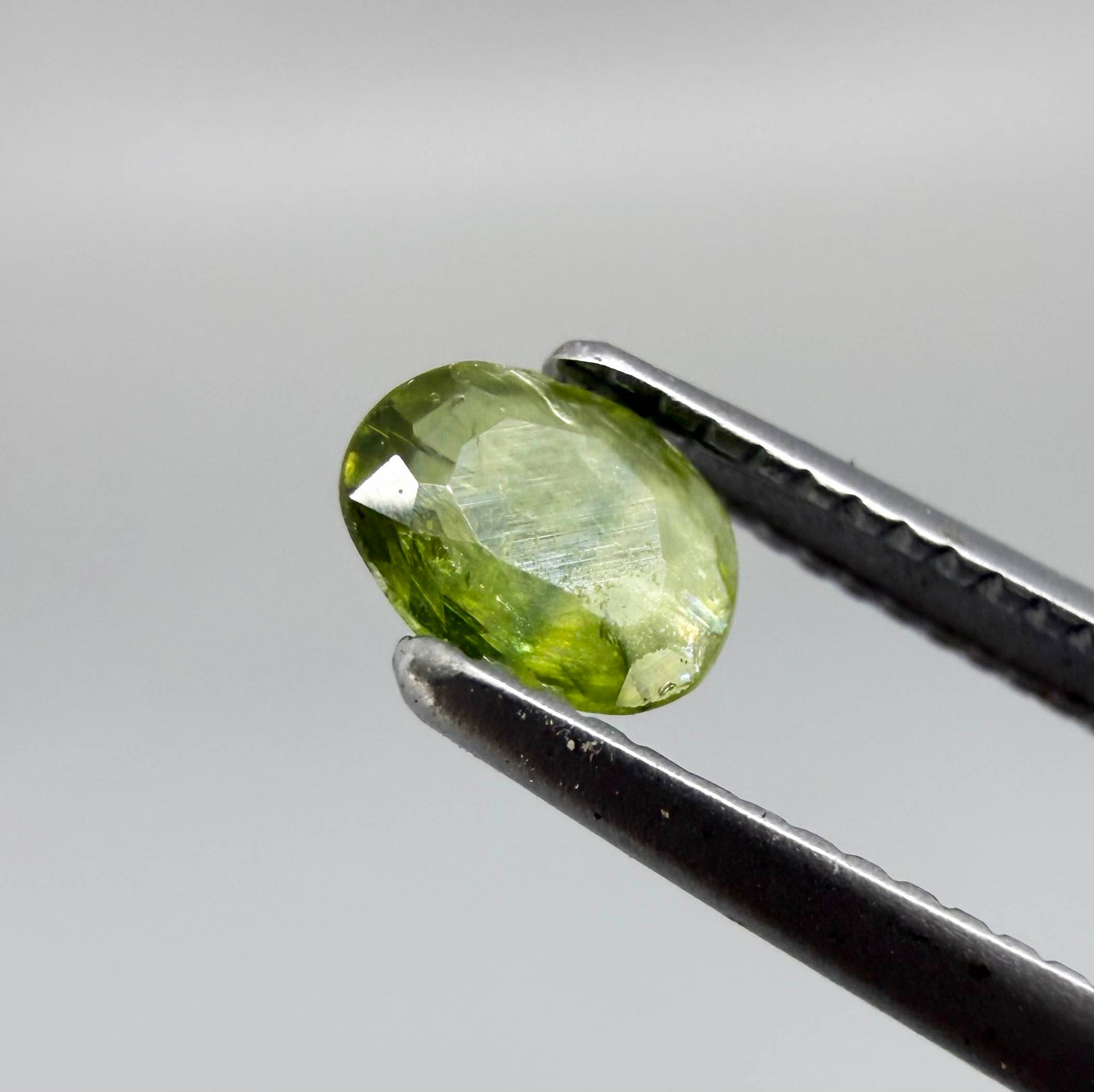 Oval light green sapphire from Thailand, 0.31ct, unheated, with fresh yellow-green color, visible natural inclusions and a transparent to slightly silky appearance.